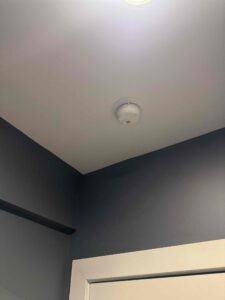 Deshaies Electrical Services installing a smoke detector as part of basement safety enhancements in the electrical project