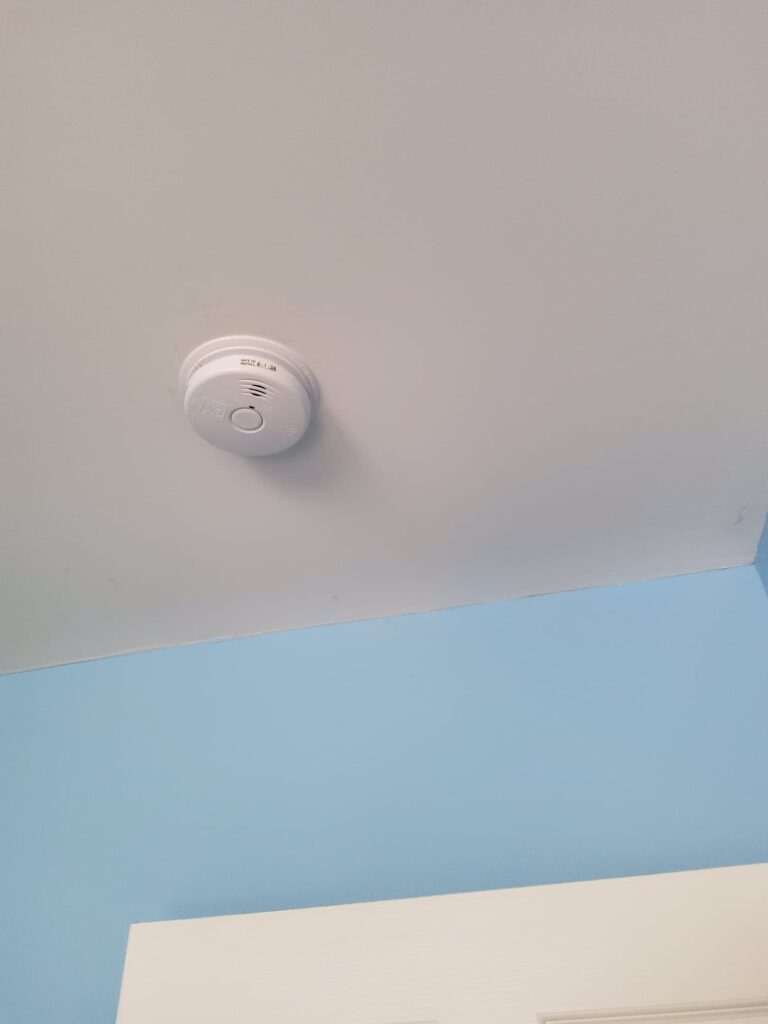 Deshaies Electrical Services installing a smoke detector in the upstairs bedroom for enhanced fire safety