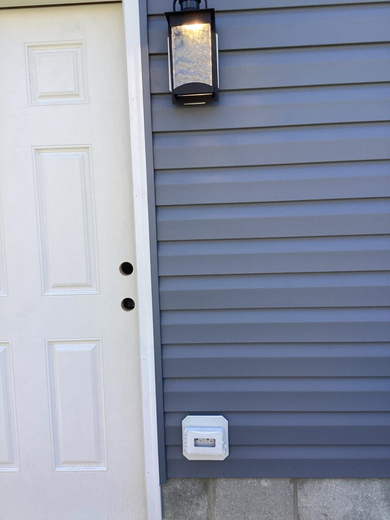 Deshaies Electrical Services installing an exterior light fixture for the garage electrical tie-in and finish project