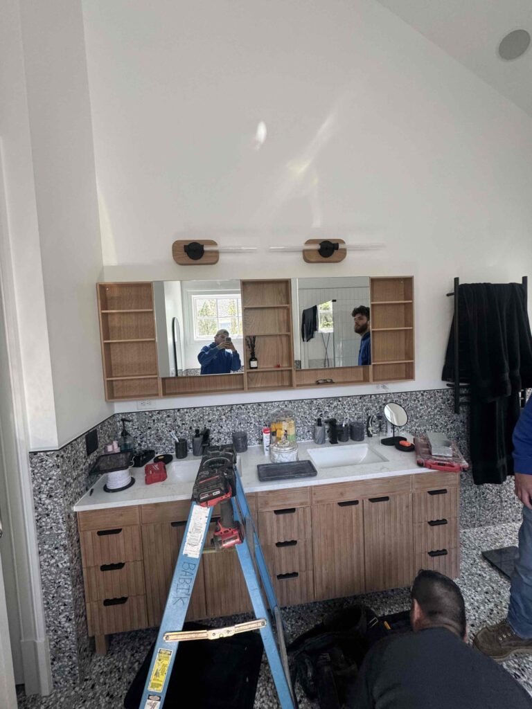 Deshaies Electrical Services installing vanity lights and replacing the collar in a bathroom setup