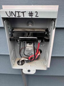 Electrical technicians servicing a circuit breaker box for comprehensive electrical service and lighting fixes