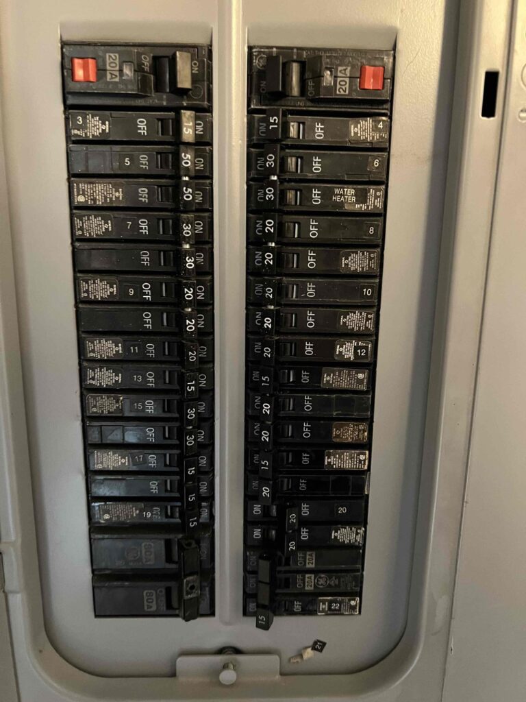 Deshaies Electrical Services inspecting and organizing the circuit breaker panel for a kitchen and laundry electrical remodel