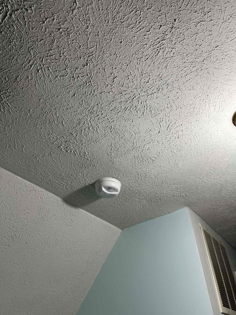 Deshaies Electrical Services installing a smoke and CO2 detector as part of a comprehensive replacement project